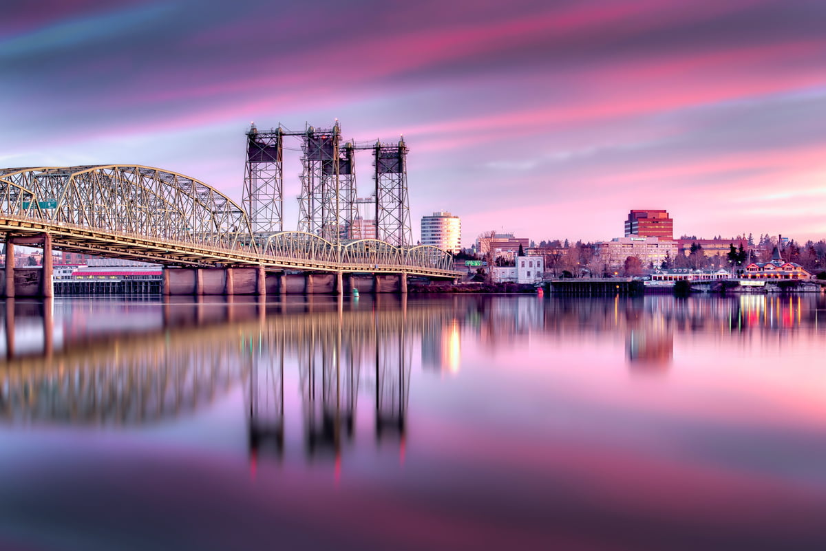 The I-5 Interstate Bridge in Vancouver, WA at sunrise with purple and pink clouds